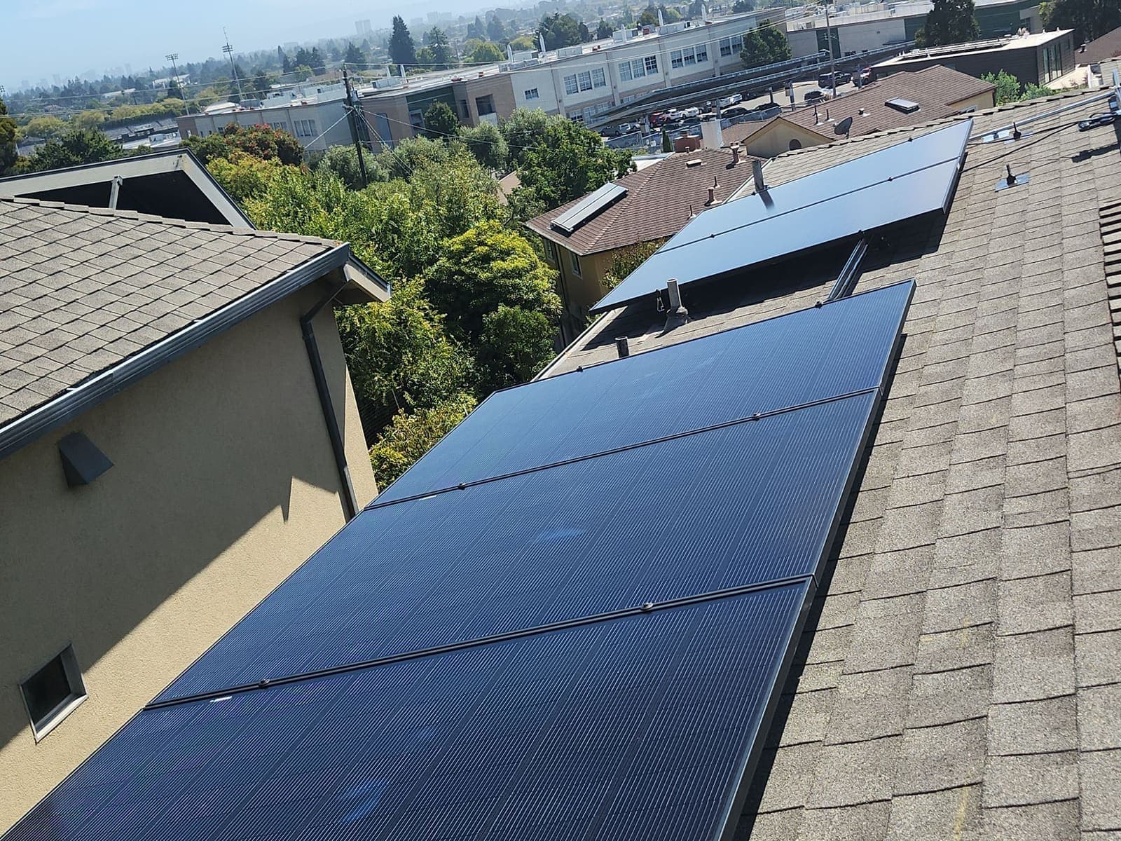 Solar panels across two roof planes on a hillside home above a town